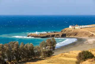 Scenic coastal view of a secluded beach with turquoise waters and rocky cliffs near Paphos, Cyprus.