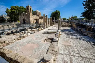 Ancient ruins with mosaic floors and stone columns at an archaeological site in Paphos, Cyprus.